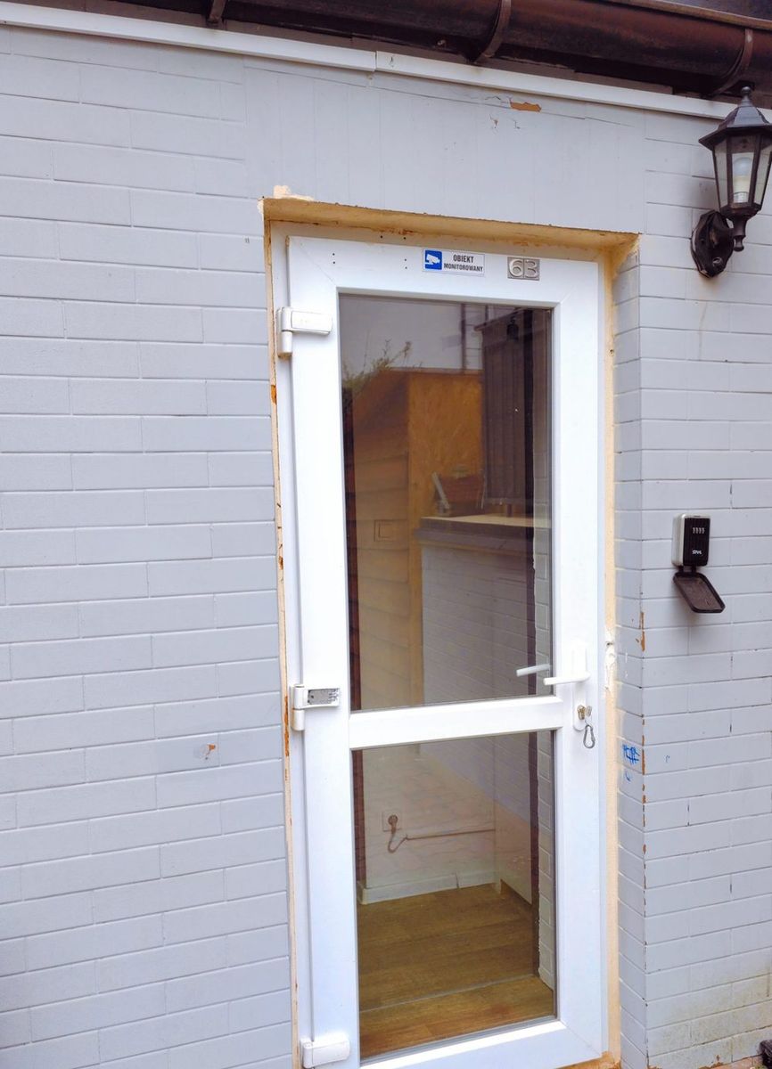 Osobne wejście do apartamentu, białe drzwi z numerem 63